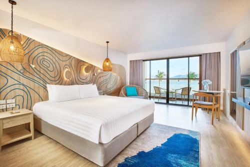 a hotel room with a bed and a view of the ocean at LIV Hotel Phuket Patong Beachfront in Patong Beach