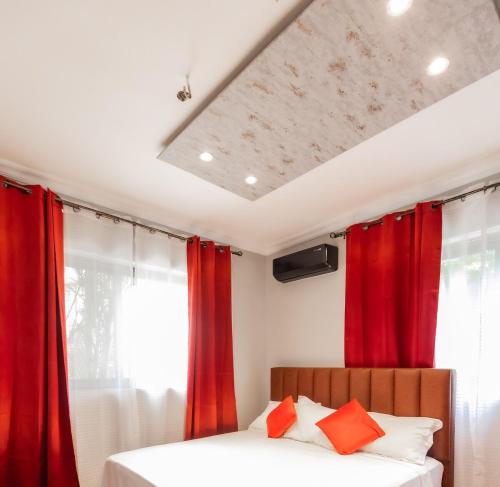 a bedroom with red curtains and a bed at Aion Suites 301 in North Legon