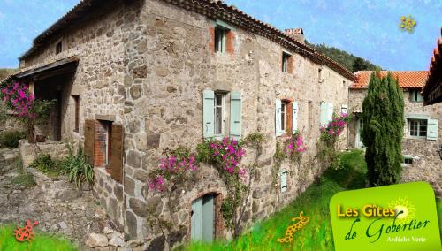 an old stone house with flowers on the side of it at Gites de Gobertier in Saint-Alban-dʼAy