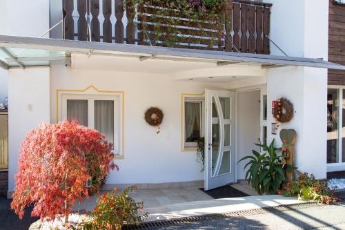 a white house with a staircase and flowers at Hotel Garni Katnau in Schenna