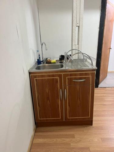 a kitchen sink in the corner of a room at Central Apartment in Cochrane