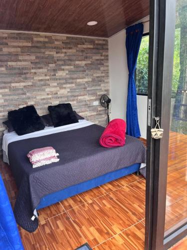 a bed in a room with a brick wall at Cabañas La Arboleda in La Vega