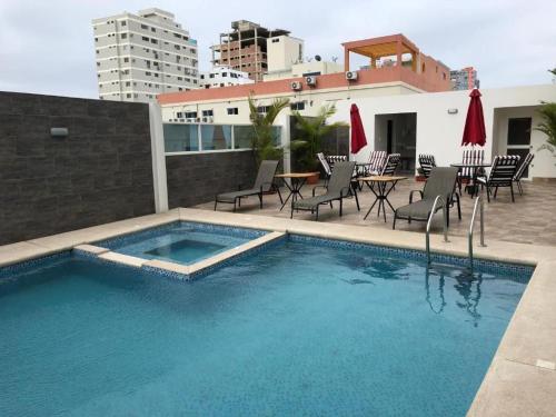 a swimming pool with chairs and a table on a building at Suite vista al Mar Salinas in Salinas