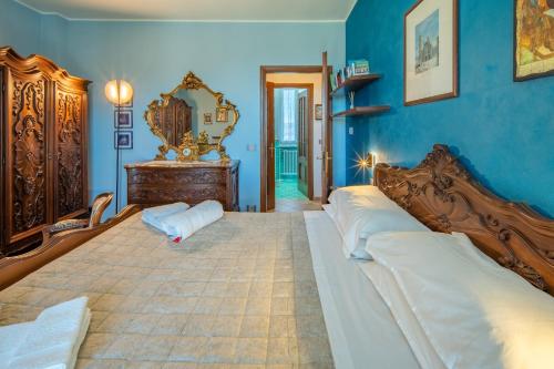 a bedroom with a large bed and blue walls at A Casa di Beppe a Monforte dAlba in Monforte dʼAlba