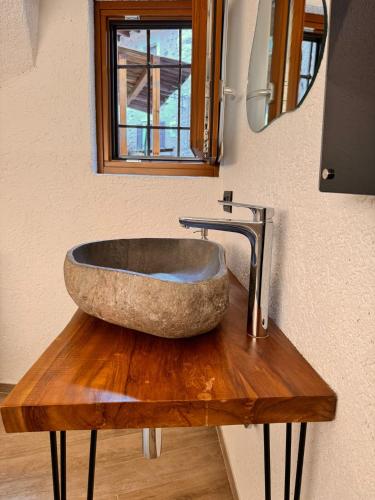 a bathroom with a stone sink on a wooden table at La Ca' nel Borgo in Tenno