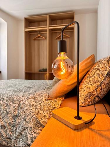 a lamp sitting on top of a bed at La Ca' nel Borgo in Tenno