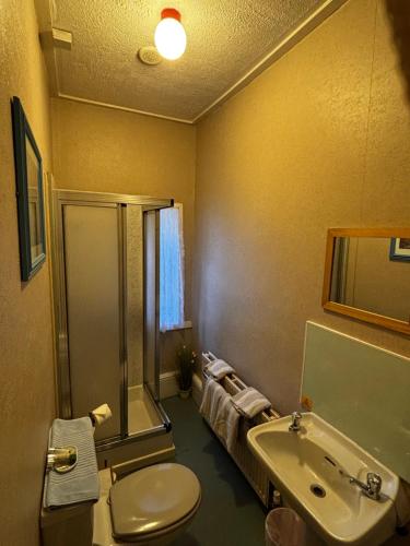 a bathroom with a sink and a toilet and a tub at Hamilton House Guest House in Oban