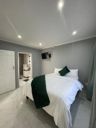a bedroom with a large white bed in a room at Villa Amari in Aliwal North