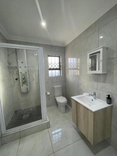 a bathroom with a shower and a sink and a toilet at Villa Amari in Aliwal North