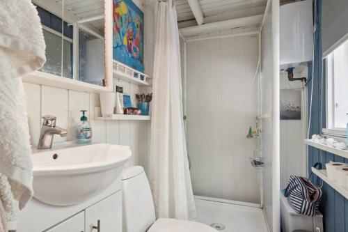 a bathroom with a sink and a toilet and a shower at KATs FRISTED in Ebeltoft