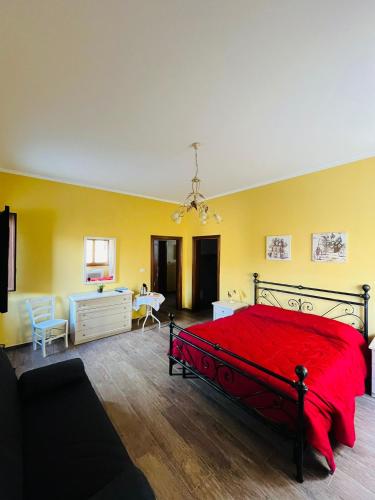 a bedroom with a red bed and a yellow wall at Santa Ittoria in Cossoine