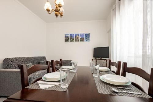 a dining room with a table with chairs and a television at AL Bela Vida in Tavira