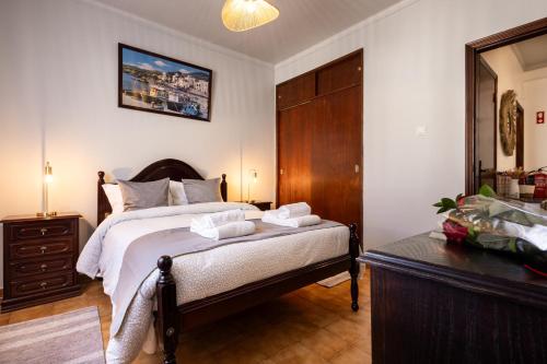 a bedroom with a bed and a table with towels on it at AL Bela Vida in Tavira