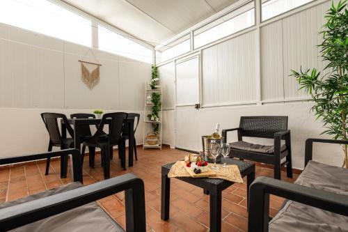 a room with black chairs and tables and windows at AL Bela Vida in Tavira