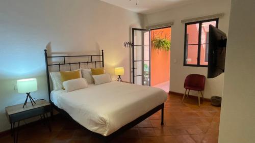 a bedroom with a large bed and a television at Casa Callejon in San Miguel de Allende