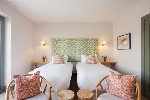 a hotel room with two beds and two chairs at Barnahown B&B, Mitchelstown in Mitchelstown