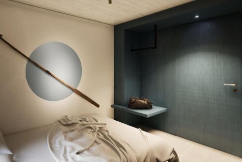 ein Schlafzimmer mit einem Spiegel an der Wand und einem Bett in der Unterkunft Schiffli - Boutique Apartments - Self Check In in Rapperswil-Jona