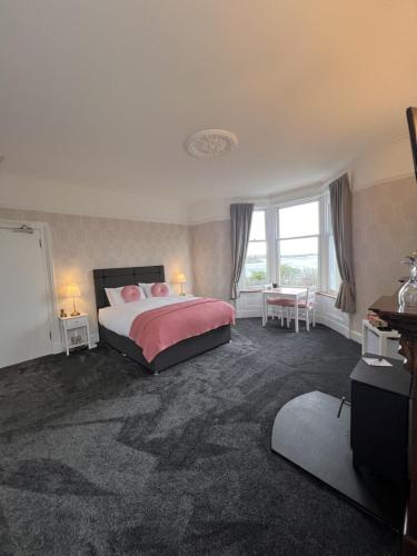 a bedroom with a large bed with pink pillows at Ronebhal Guest House in Oban