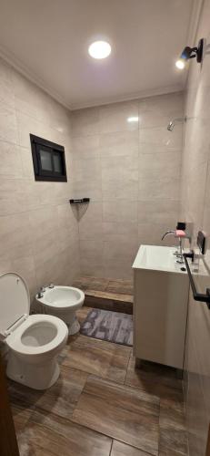 a bathroom with a toilet and a sink at Oasis Atlántida in Santa Clara del Mar