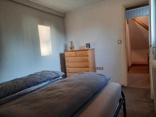 two beds in a room with a dresser and a bedroom at Herzenshaus Sauerland in Diemelsee