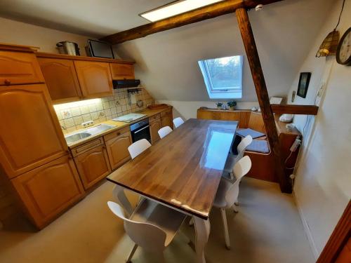 an overhead view of a kitchen with a wooden table and chairs at Herzenshaus Sauerland in Diemelsee
