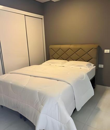 a bedroom with two beds with white sheets at Hospedaria Santo Descanso (Edícula) in Uberlândia