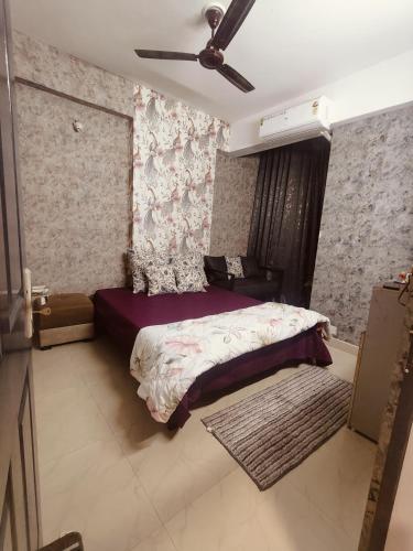 a bedroom with a bed and a ceiling fan at StudeXO in Ghaziabad