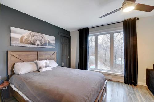 a bedroom with a bed with a picture of a bear on the wall at Lake Joseph Retreat -Waterfront and Hot tub in Saint-Pierre-Baptiste