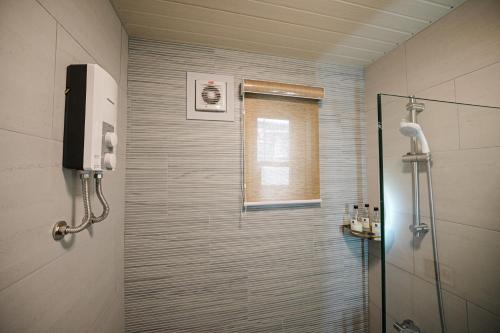 a shower with a glass door in a bathroom at Casita Benito Loft A in Sangley Point Naval Station