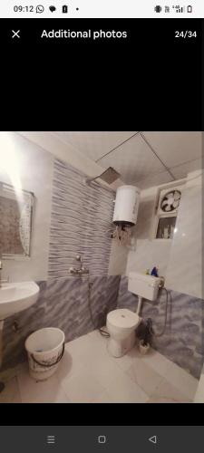a bathroom with a toilet and a sink at StudeXO in Ghaziabad