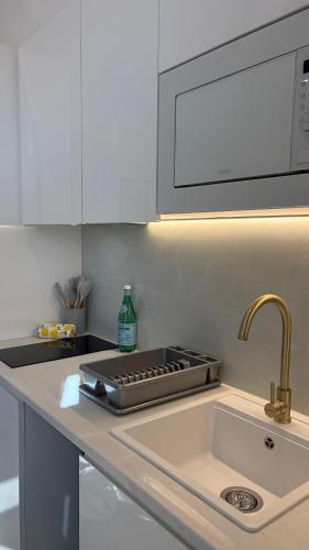 a kitchen counter with a sink and a microwave at MAGNO- Beach in Valencia