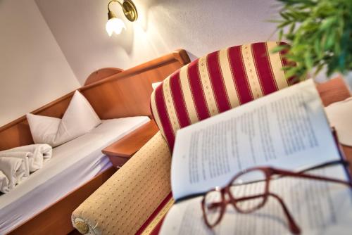 a table with a book and a pair of glasses at Hotel Garni Katnau in Schenna