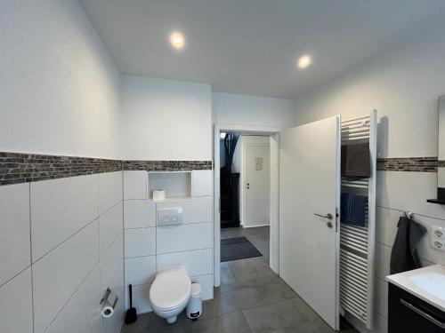 a white bathroom with a toilet and a sink at Villa Maria in Westerburg