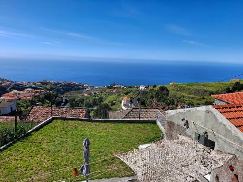 a view of a field of grass with the ocean in the background at Casa Rosinha in Calheta