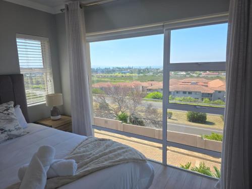a bedroom with a bed and a large window at Heuwels Haven in Mossel Bay