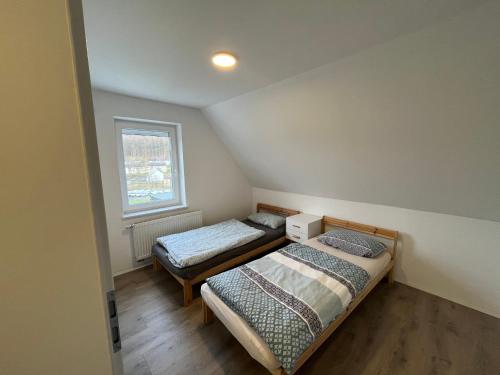 two beds in a small room with a window at Villa Maria in Westerburg