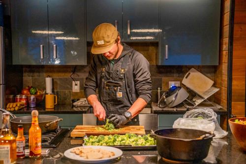 a man preparing food in a kitchen at Campfire Ranch Private Cabin, Meals Included in Bergen Park