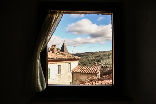 a window view of a town from a building at Antico Borgo Seggiano in Seggiano