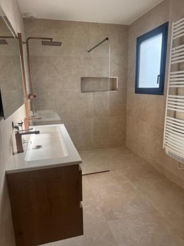 a bathroom with a sink and a window at VILLA du VERNET avec JACUZZI in Vernet