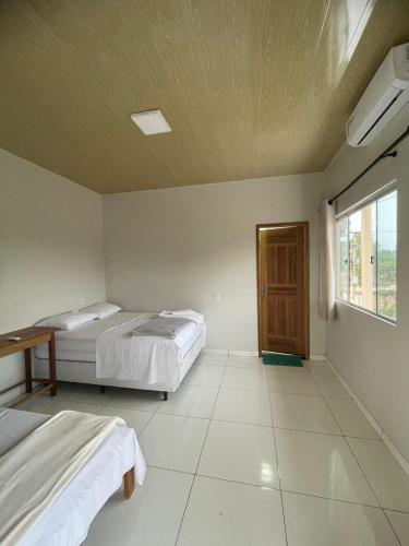 a bedroom with two beds and a window at Pousada Serena - Alter do Chão in Santarém