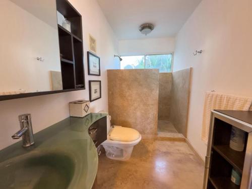 a bathroom with a sink and a toilet at Casa Ruma Beachfront Art House in Bahía Kino