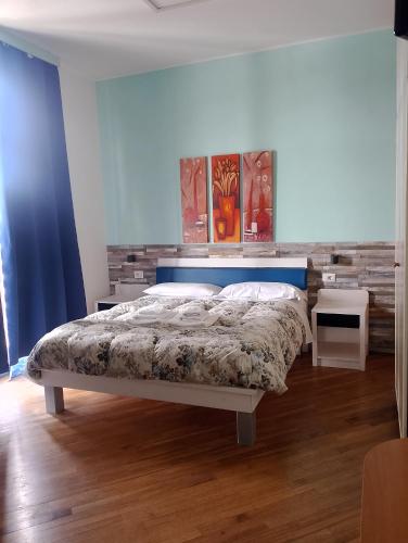 a bedroom with a bed with a blue headboard at Affittacamere Le Ginestre in Colleferro