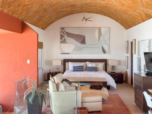 a bedroom with a bed and a couch in it at Casa Ruma Beachfront Art House in Bahía Kino