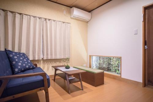 a living room with a blue couch and a table at Nijojo Taiken Inn in Kyoto