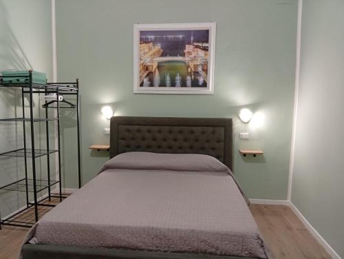 a bedroom with a bed and a picture on the wall at Le Suite di Antonella in Taranto