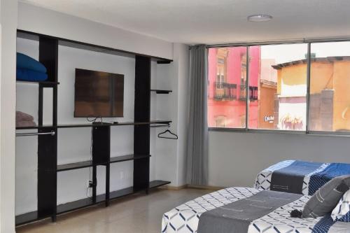 a bedroom with two beds and a flat screen tv at Centro Histórico Hermosos Departamentos, Casas Freda in San Luis Potosí