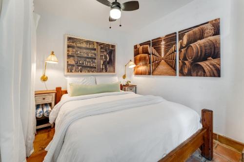 a bedroom with a white bed and two pictures on the wall at BOOTLEGGER BAY @ Speakeasy Inn Key West! in Key West