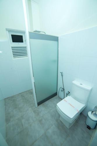 a white bathroom with a toilet and a shower at Range Kandy in Kandy