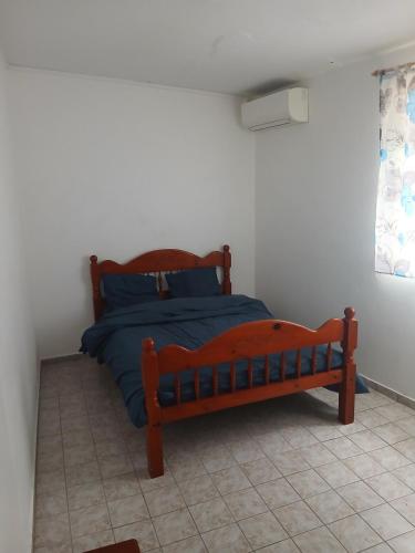 a bedroom with a wooden bed in a room at Haut de Villa Manguier in Petit-Bourg