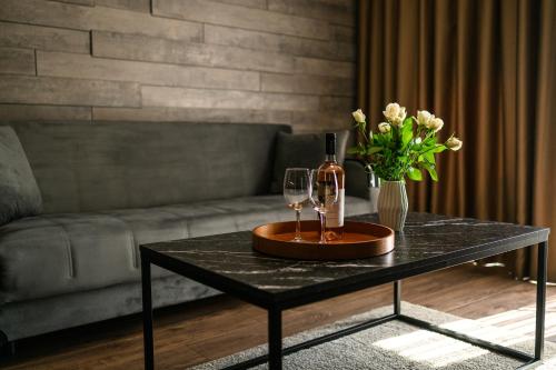 a black coffee table with a bottle of wine and flowers at Libertè suites Velingrad in Velingrad